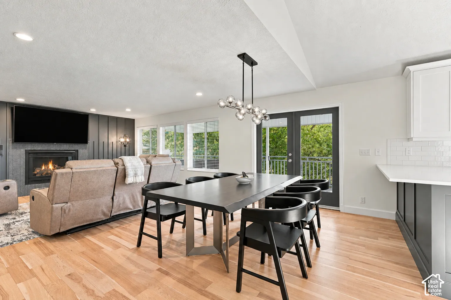 Hardwood flooring throughout, recessed lighting, and a modern linear chandelier