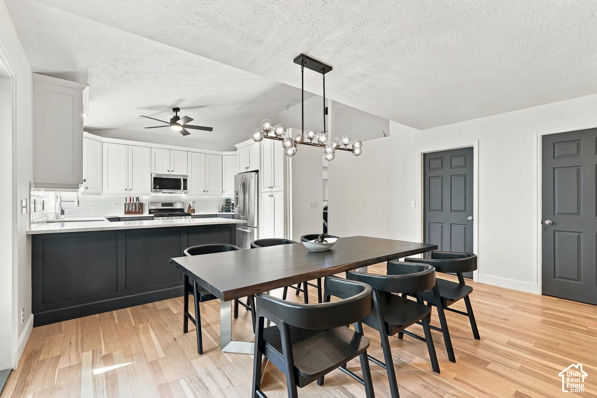 Kitchen with two-tone cabinetry, stainless steel appliances, and a white subway tile backsplash