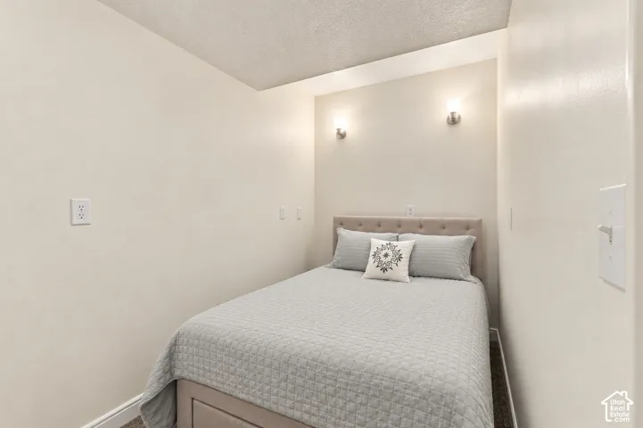 Recessed lighting, neutral wall tones, and wall-mounted sconces
