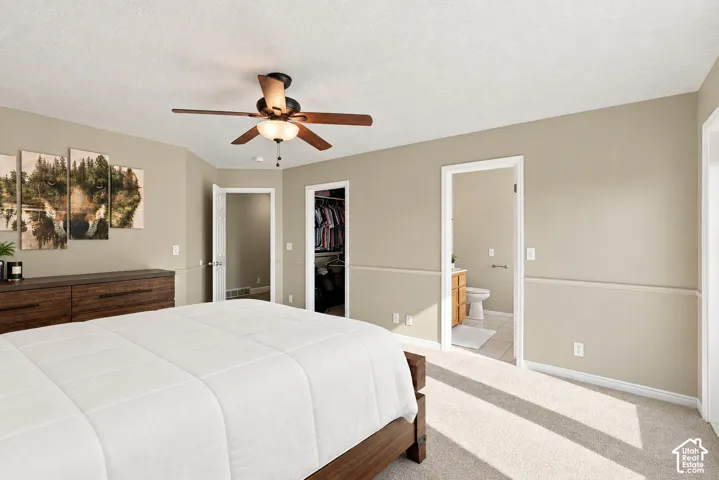 Neutral-toned walls with chair rail molding, carpeted flooring, and a ceiling fan with integrated lighting