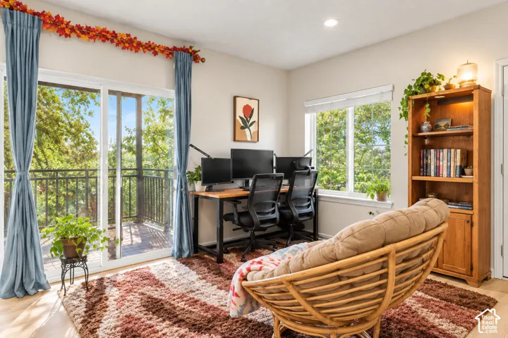 Hardwood-finish flooring, built-in shelving, recessed lighting, and a sliding glass door providing outdoor access