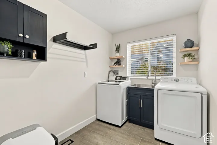 Laundry area featuring built-in cabinetry, a utility sink, and wood-finish flooring