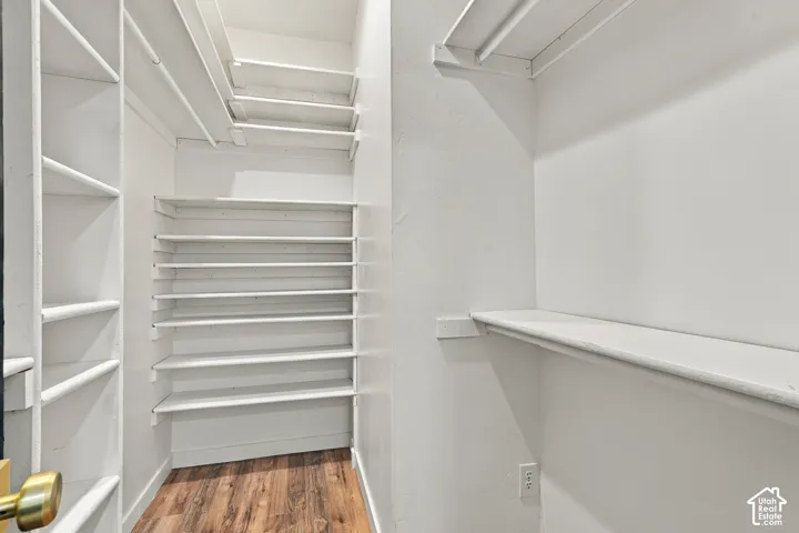 Built-in shelving units, white painted walls, and wood-finish flooring