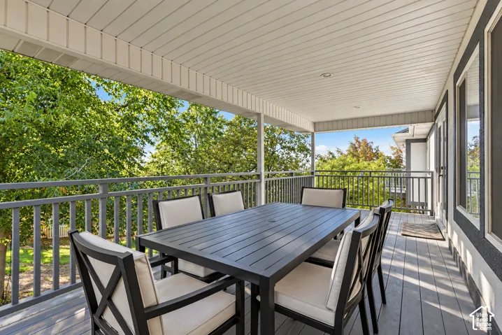 Covered outdoor deck with composite decking, recessed lighting, and dark grey railing