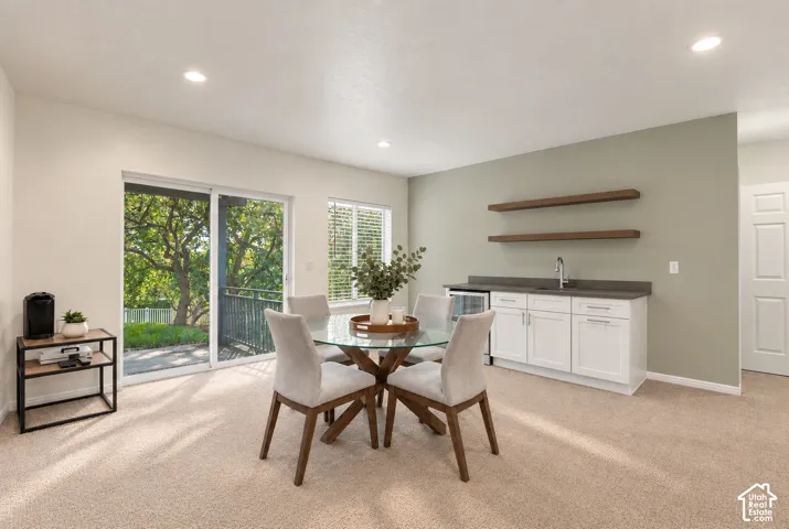 Built-in wet bar with white cabinetry, dark countertop, and integrated beverage refrigerator