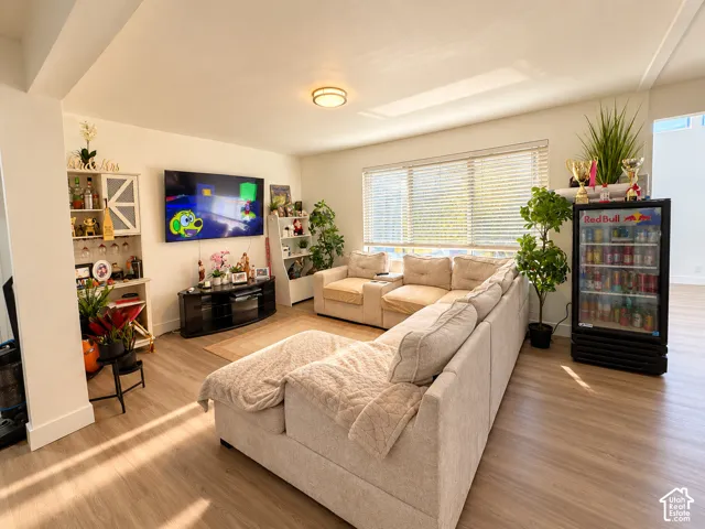 Wood-finish flooring throughout, large windows with blinds, and a built-in display shelf