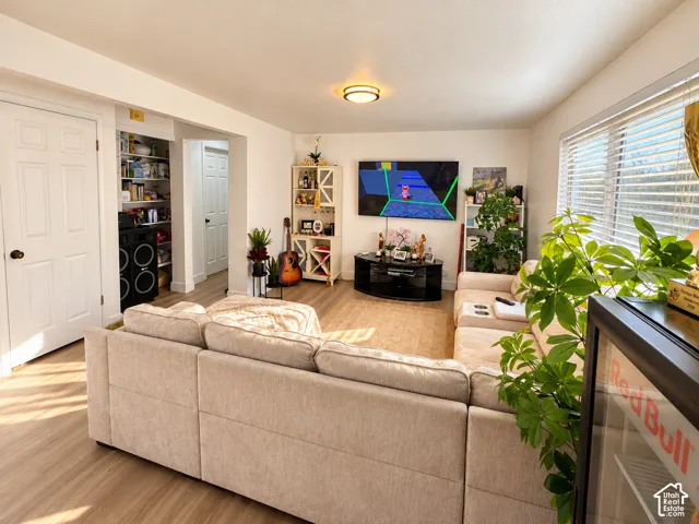 Recessed lighting, wood-finish flooring, white interior doors, built-in shelving, and window blinds