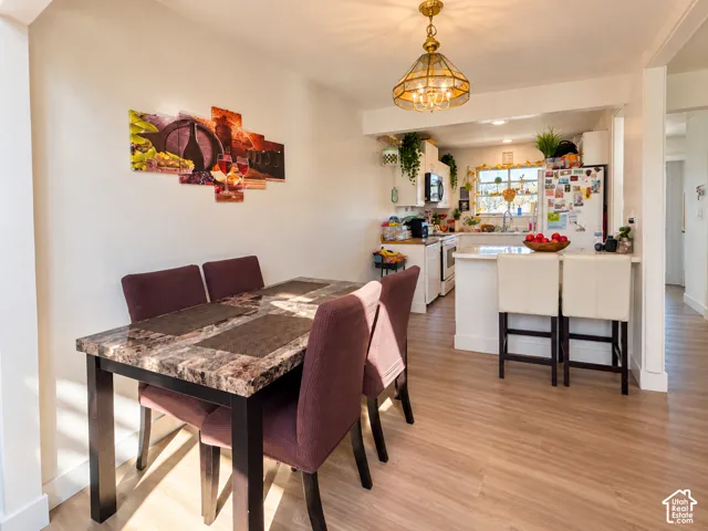 Open-concept kitchen and dining area featuring wood-finish flooring, recessed lighting, and a kitchen island with seating