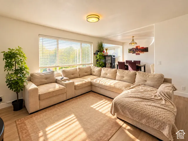 Open-concept living space with wood-finish flooring, recessed lighting, and a large window