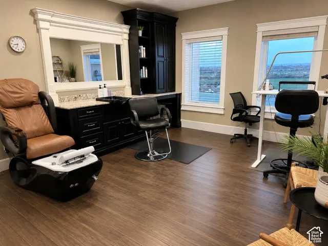 Wood-finish flooring throughout, featuring a built-in cabinetry with a light-toned countertop, and multiple windows with white trim