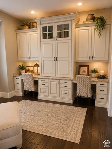 Built-in cabinetry with glass-front uppers, granite countertops, recessed lighting, and wood-finish flooring