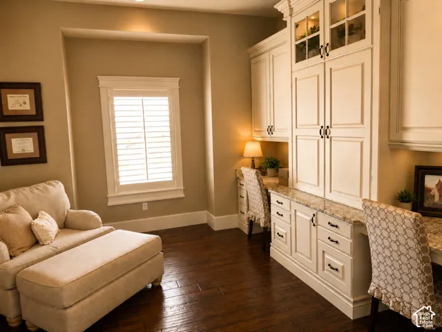 Dark wood-finish flooring with built-in cabinetry featuring glass-front doors