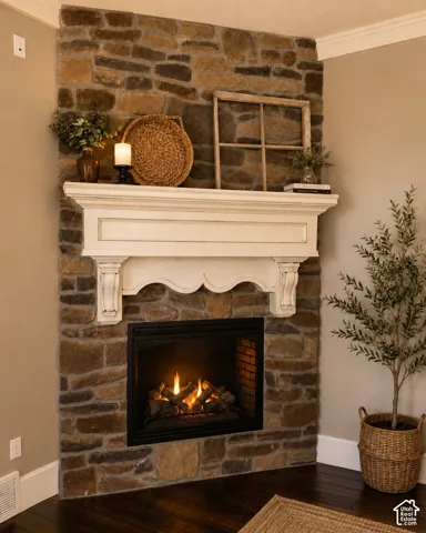 Stone-clad fireplace featuring a white carved mantel, corbel supports, and a built-in firebox with log insert