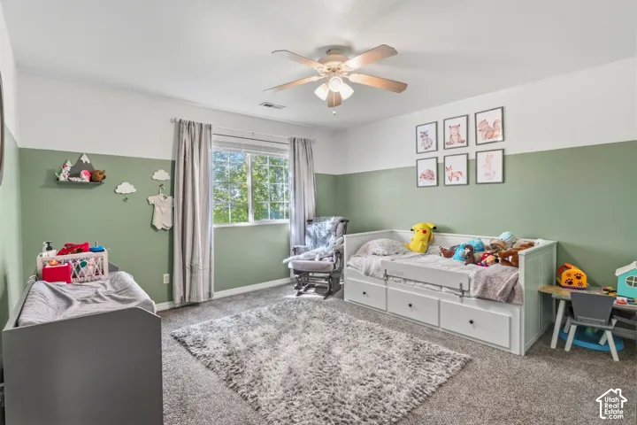 Recessed window with exterior views, ceiling fan, and carpeted flooring