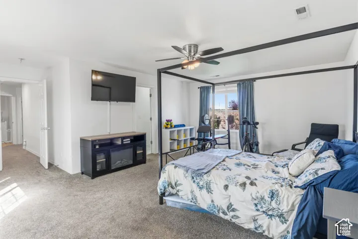 Recessed lighting, ceiling fan, carpet flooring, and a built-in media console with an electric fireplace