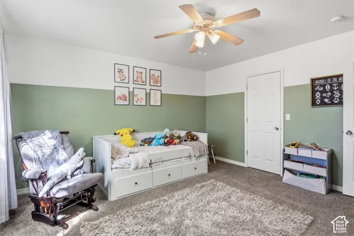 Room featuring two-tone walls, ceiling fan with integrated lighting, and carpet flooring