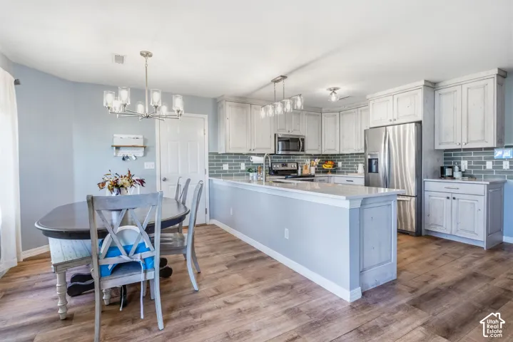 Wood-finish flooring throughout, with a dining area illuminated by a chandelier