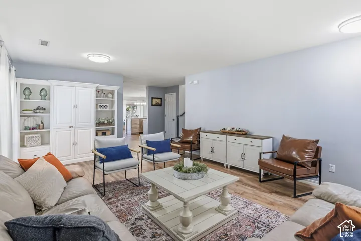 Wood-finish flooring throughout, light blue wall paint, white built-in cabinetry, and white ceiling light fixtures