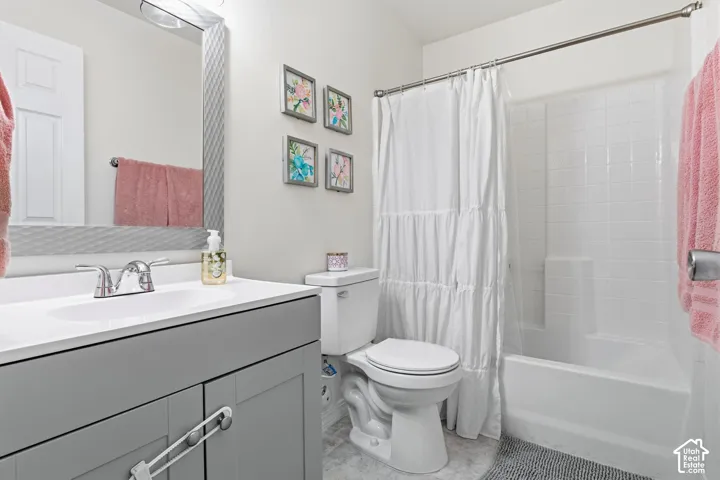 Bathroom featuring a single vanity with gray cabinetry, a white countertop, and a chrome faucet