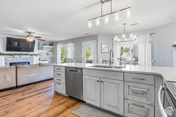 Kitchen island with white countertop, integrated sink, and stainless steel dishwasher