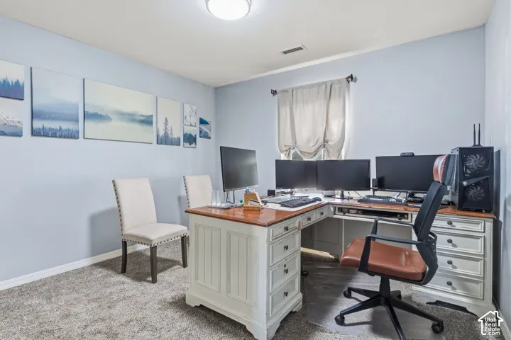 Light-toned walls, carpeted flooring, and a single window with drapes