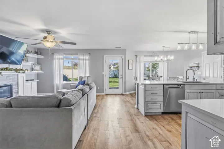 Wood-finish flooring throughout, featuring a kitchen island with light-toned cabinetry and a stainless-steel dishwasher