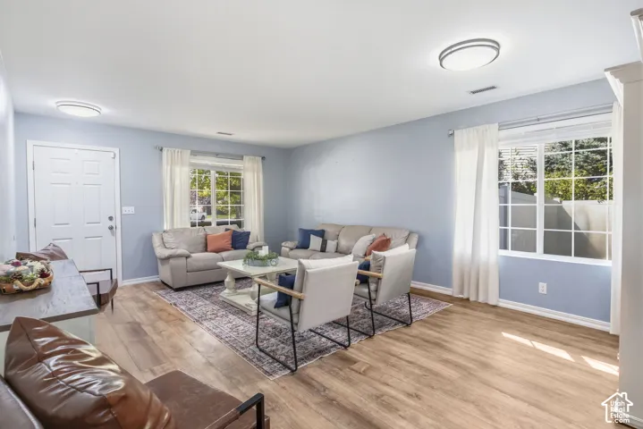 Wood-finish flooring throughout, light blue wall paint, white trim, and recessed lighting fixtures