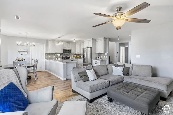Open concept living space with wood-finish flooring, a ceiling fan, and recessed lighting