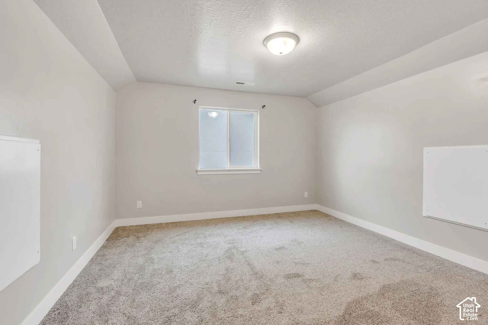 Recessed ceiling detail, neutral wall paint, white trim, window with privacy glass, and ceiling-mounted light fixture