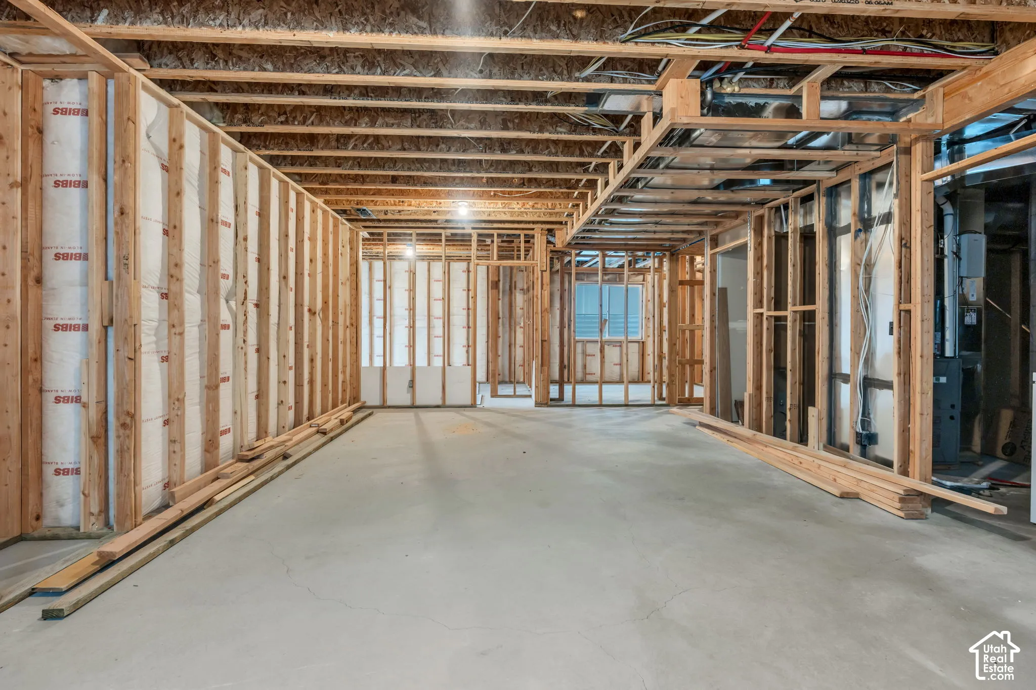 Unfinished interior space featuring wood framing, exposed joists, and concrete flooring