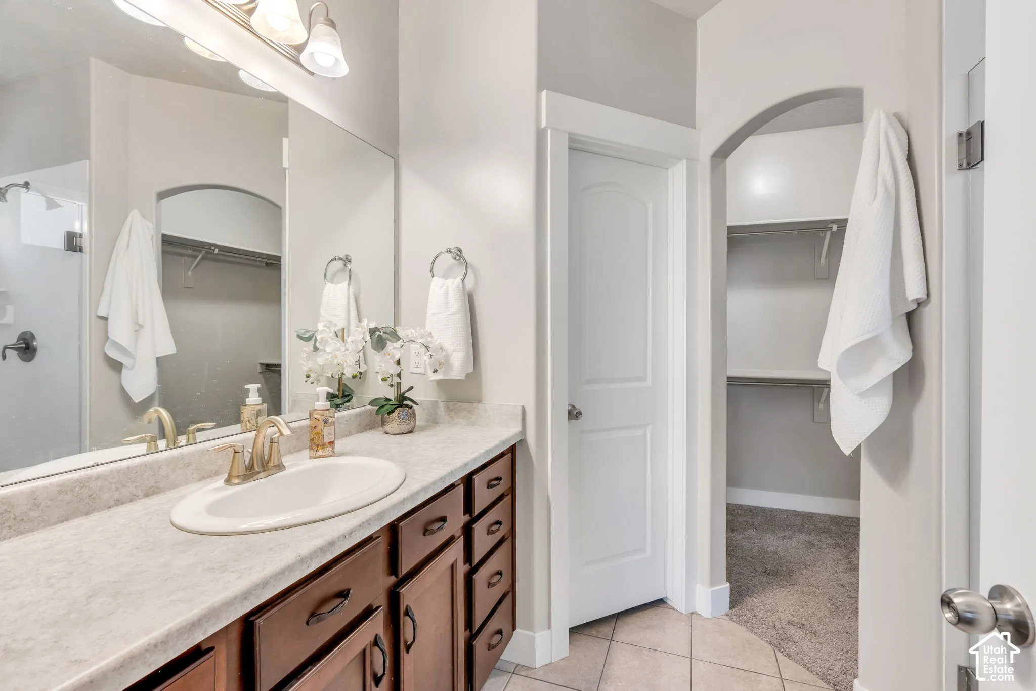 Wood-finish vanity with an integrated sink and brushed gold-tone faucet