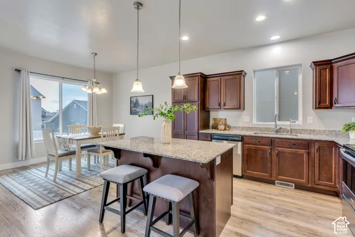 Kitchen with wood-finish flooring, dark wood cabinetry, and light-toned countertops