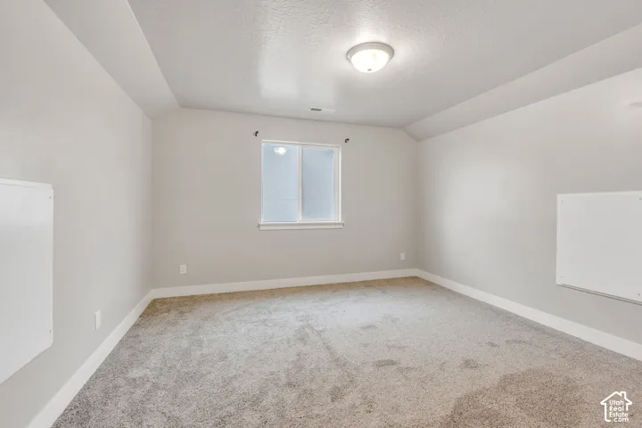 Recessed ceiling detail, neutral wall paint, white trim, window with privacy glass, and ceiling-mounted light fixture