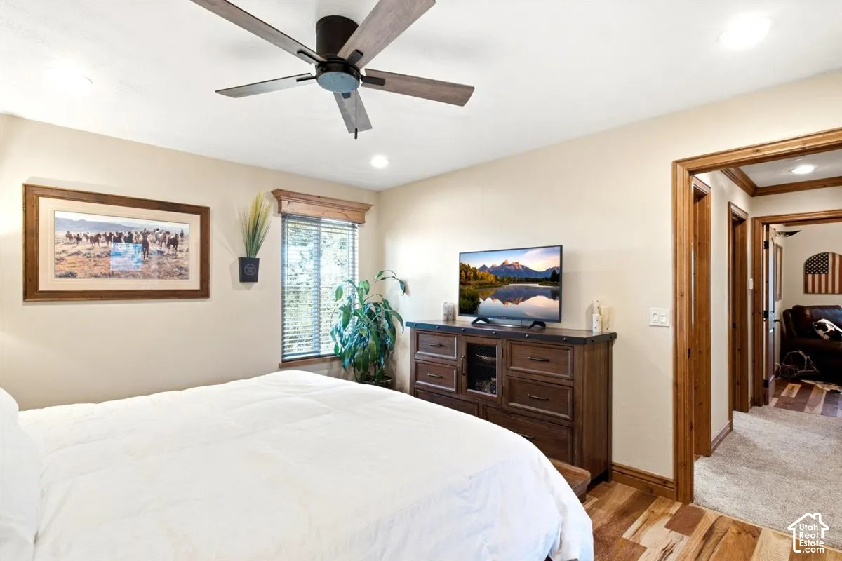 Wood-finish flooring throughout, featuring a ceiling fan with integrated lighting