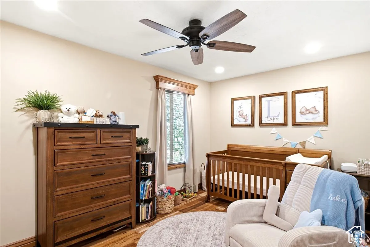 Wood-finish flooring, recessed lighting, and a ceiling fan with wood-finish blades