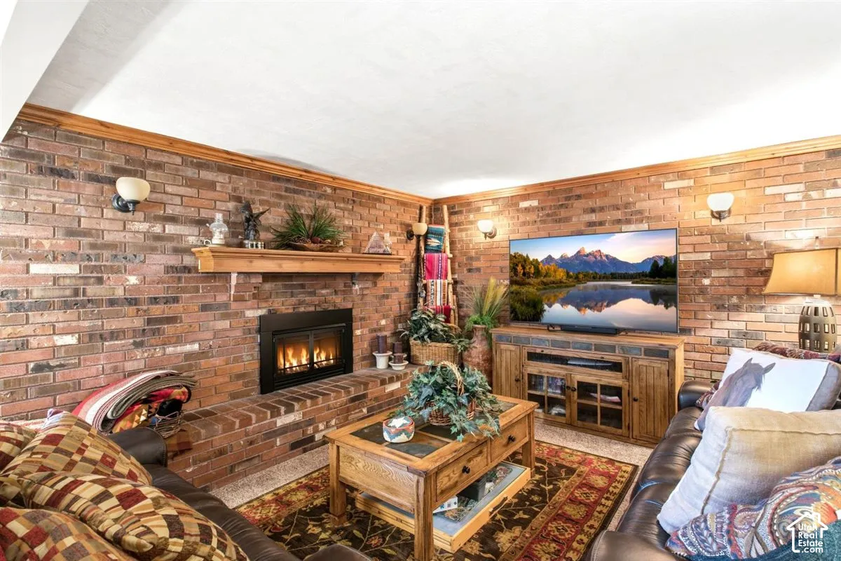 Brick-clad walls featuring sconce lighting, a built-in fireplace with a hearth, and a wood mantel