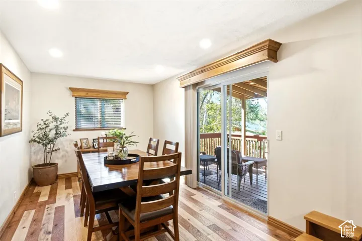 Wood-finish flooring, recessed lighting, wood window trim, wood cornices, and a sliding glass door
