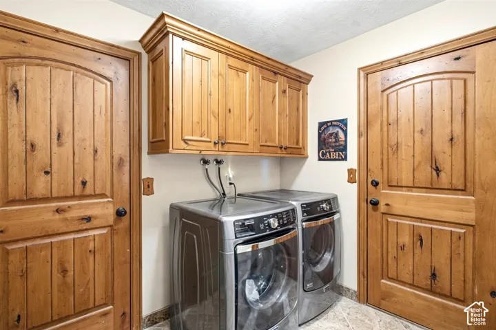 Laundry area featuring wood-finish cabinetry, tile flooring, and two wood-finish doors