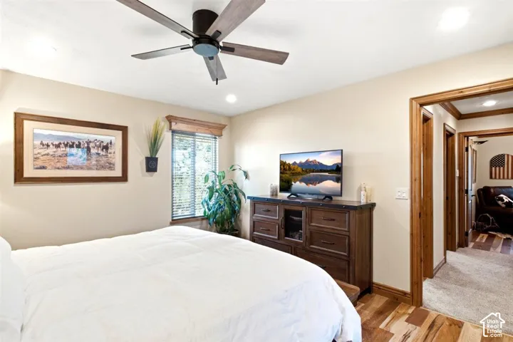 Wood-finish flooring throughout, featuring a ceiling fan with integrated lighting