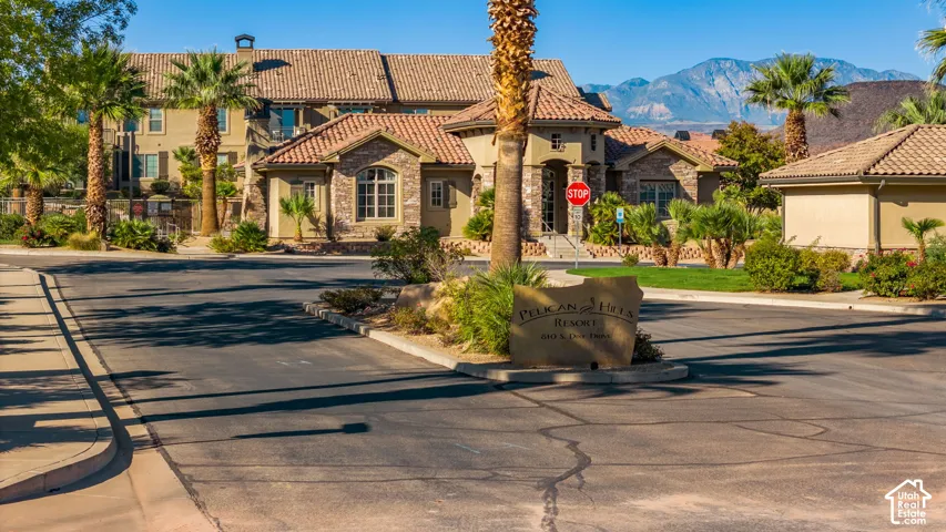 Mediterranean-style architecture with stucco and stone accents, concrete tile roofing, and mature palm trees