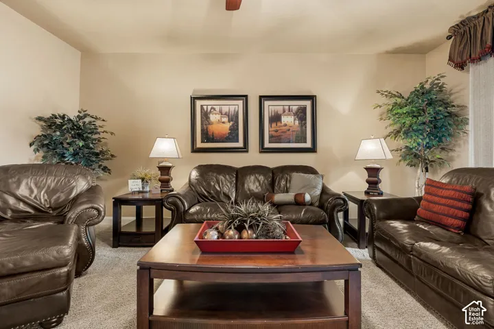 Neutral wall paint, light-colored carpeting, and a ceiling fan with light fixture