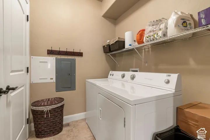 Laundry area featuring a built-in wire shelf, overhead storage, and tile flooring