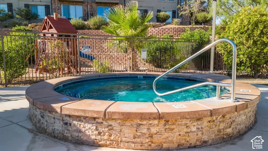 Circular spa with stone veneer and a concrete coping