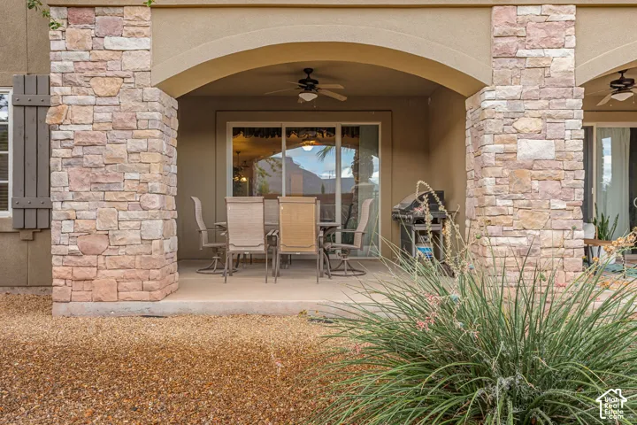 Covered patio with stone-clad columns and an arched entryway