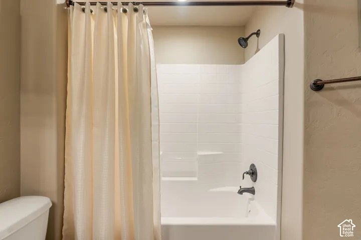 White subway tile surround, matte black shower fixtures, integrated tub, and towel bar