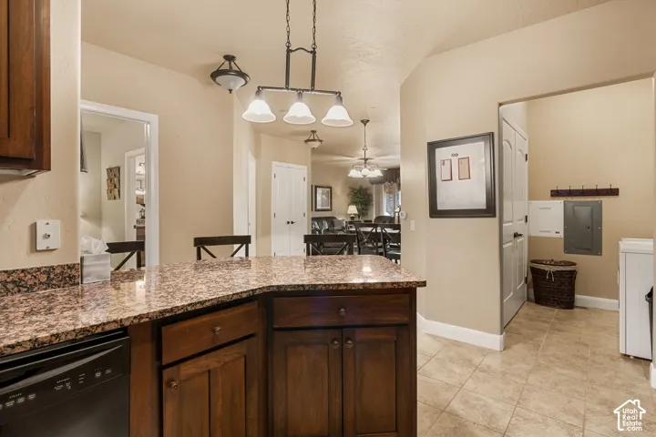 Kitchen featuring a dark wood-finish island with a mottled countertop, recessed lighting, and tile flooring
