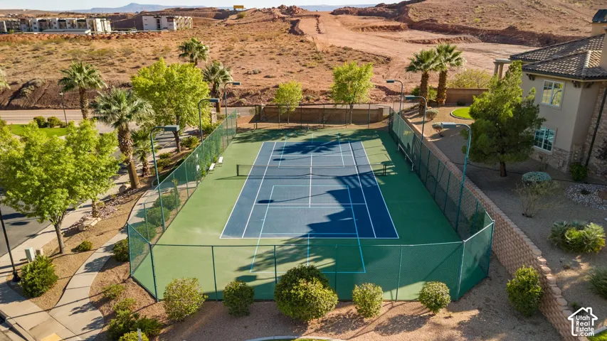 Tennis court with a green and blue surface, enclosed by a perimeter fence