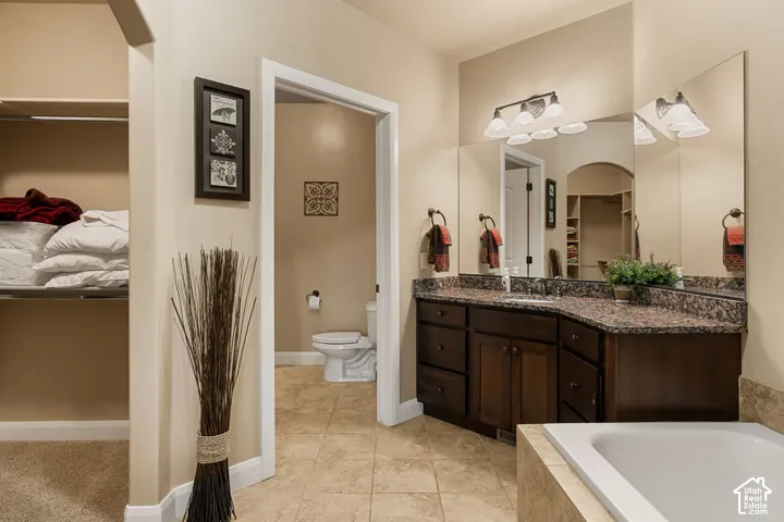 Dual vanity with dark wood-finish cabinetry, speckled countertop, and large mirrors
