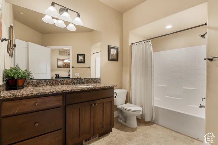 Granite-look countertop with an integrated sink, dark wood-finish vanity with drawer and cabinet storage, full-width mirror, white subway-style tile bath surround, and a white bathtub