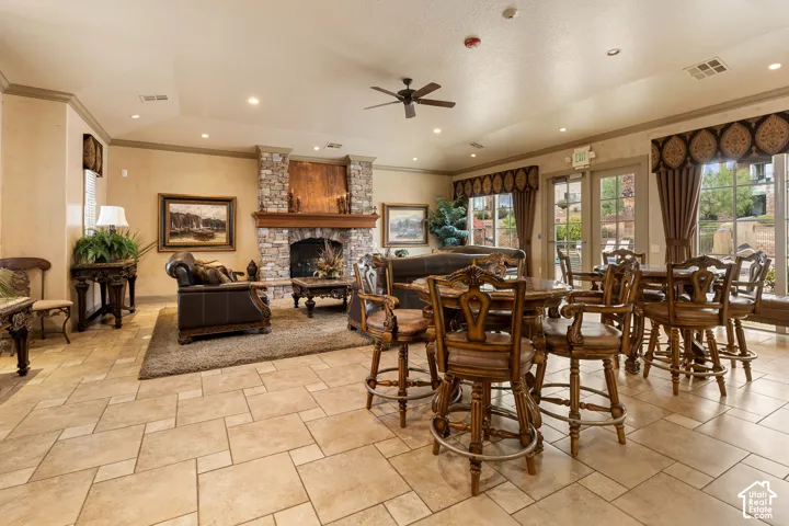 Spacious common area featuring large format tile flooring, a stone fireplace with a wood mantel, recessed lighting, and french doors